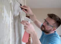 home repairs focused man removes old wallpaper fr 2021 09 04 07 51 33 utc 1