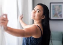 asian woman open lace curtains at window in home 2022 02 05 01 47 27 utc 1