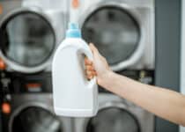 holding bottle with detergent at the laundry 2021 09 02 04 30 14 utc 1