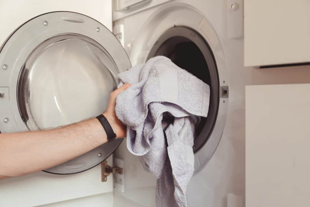 man loading color clothes and towels into built in 2022 02 07 07 27 19 utc 1