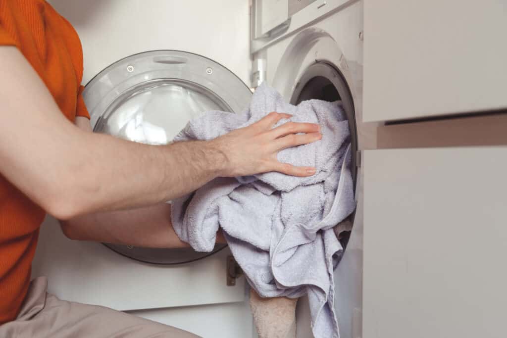 man loading color clothes and towels into built in 2022 02 07 11 49 25 utc 1 1