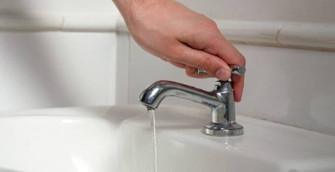 a white male hand turning off a sink faucet 2022 01 26 21 00 49 utc
